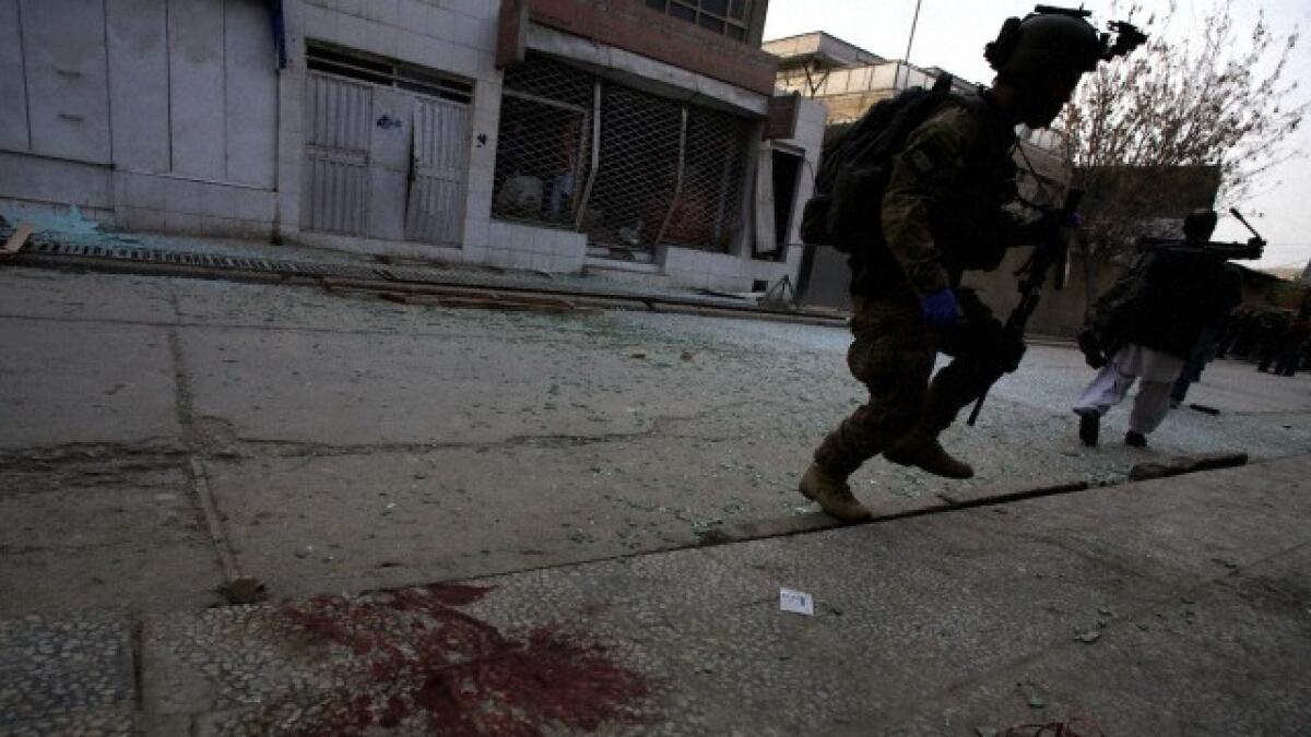  Security forces walk past blood stained street in Afghanistan