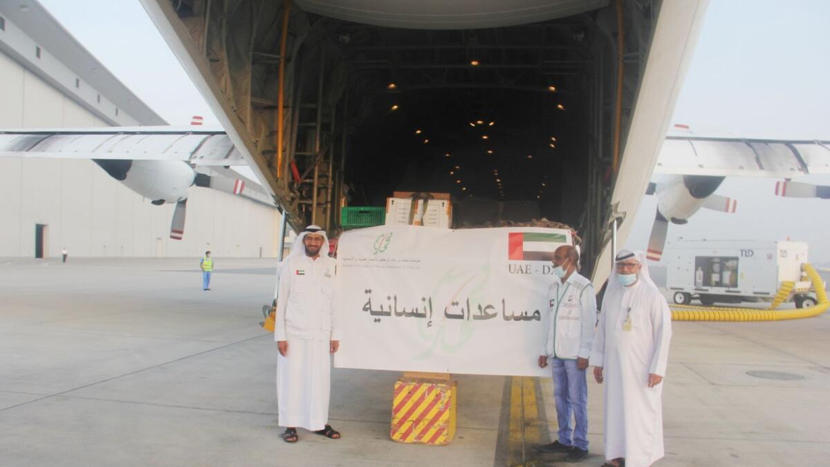 Mohammed bin Rashid Al Maktoum Humanitarian and Charity Establishment officials in front of the plane carrying food supplies to Afghanistan. — Wam