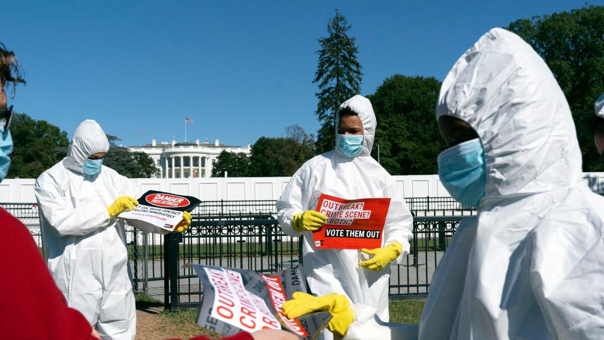 A group from MoveOn.org Political Action protests the ongoing outbreak of coronavirus in the White House, outside the White House in Washington. - AP