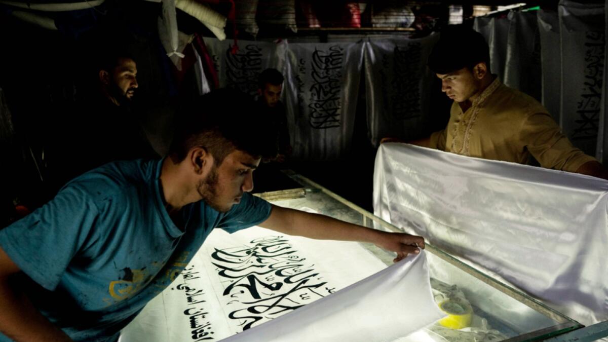Workers prepare Taliban flags at Honarwer's flag shop in Kabul. — AFP
