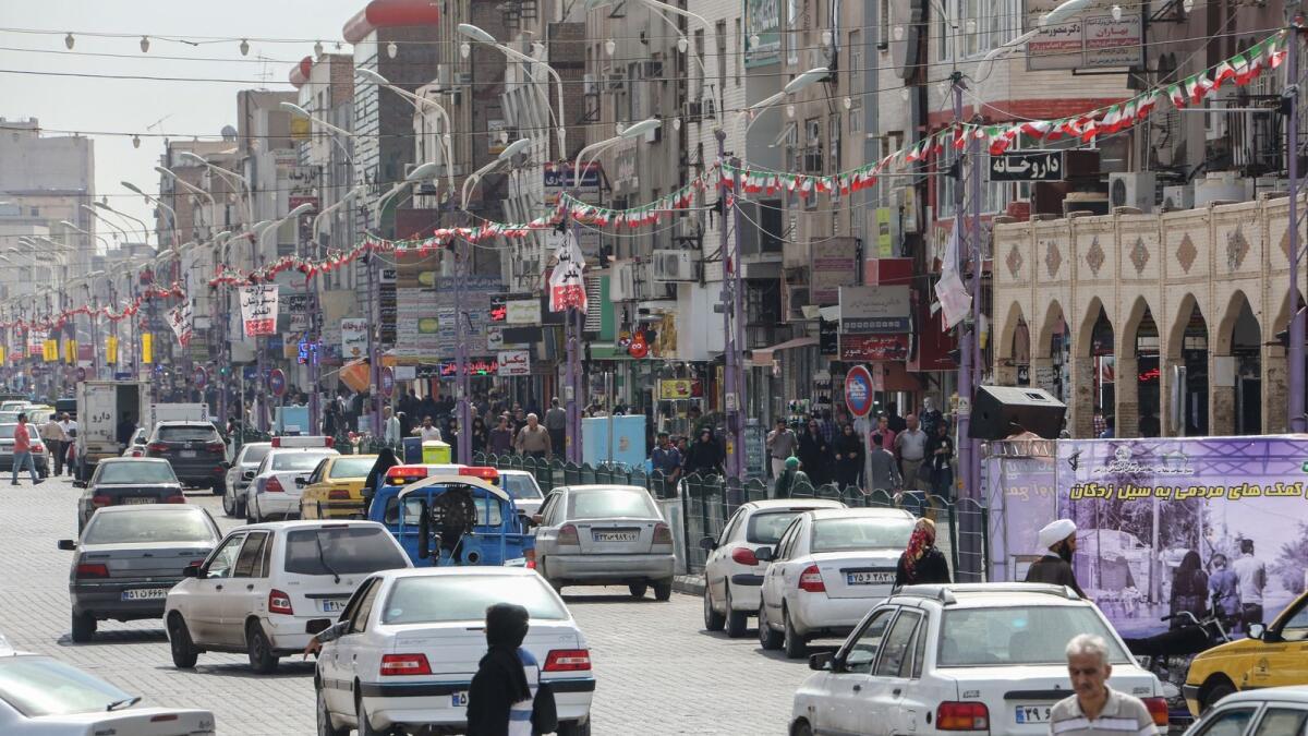 People cross a street in Ahvaz, the capital of Khuzestan. Photo: AFP