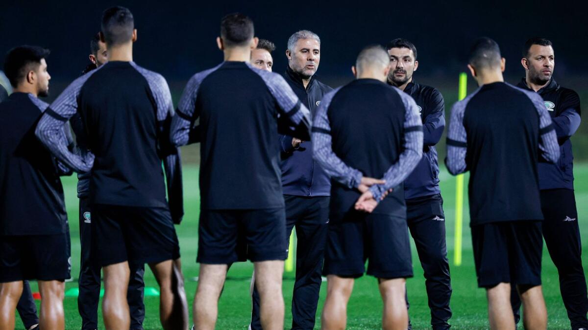 Palestine's Tunisian coach Makram Daboub (C) instructs his players during a training session in the Qatari capital. - AFP