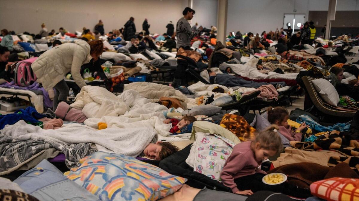 People rest in a temporary shelter for Ukrainian refugees, located near the Polish-Ukrainian border in a former shopping centre in Przemysl, Poland, on March 8, 2022. As of that day, more than two million people had fled Ukraine. (Photo: AFP)