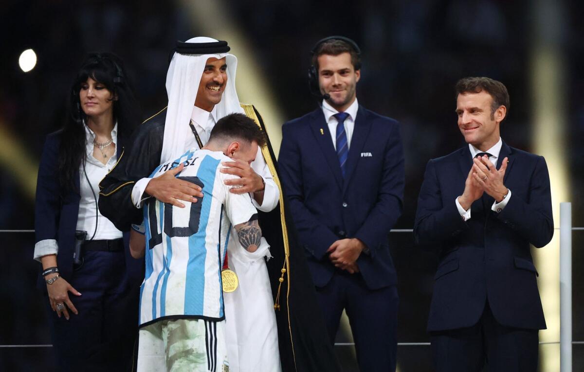 Argentina's Lionel Messi hugs Emir of Qatar Sheikh Tamim bin Hamad Al Thani as French President Emmanuel Macron looks on