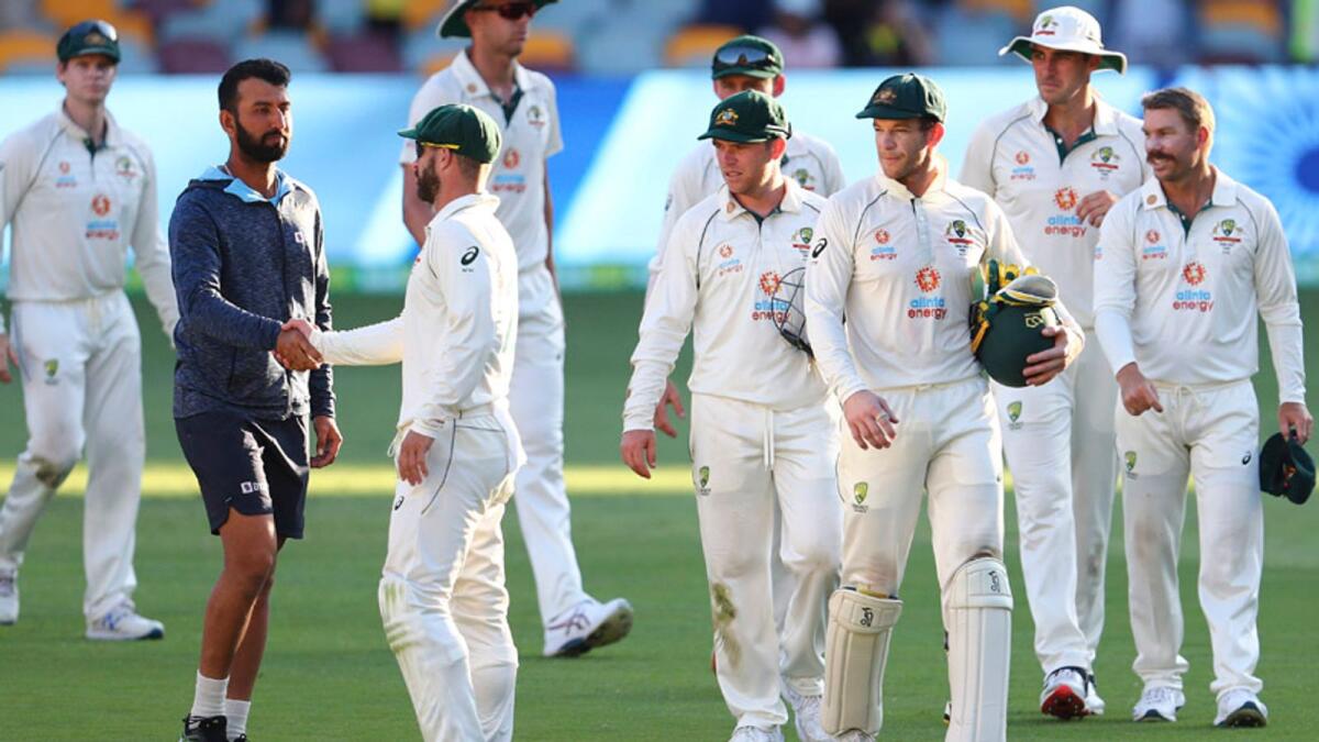India's Cheteshwar Pujara (second left) is congratulated by Australia's Matthew Wade  on the final day of the fourth cricket test at the Gabba. — AP