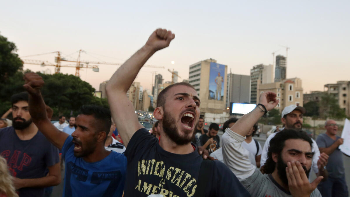 Lebanese activists chant slogans during a march against the trash crisis and government corruption in Beirut streets.