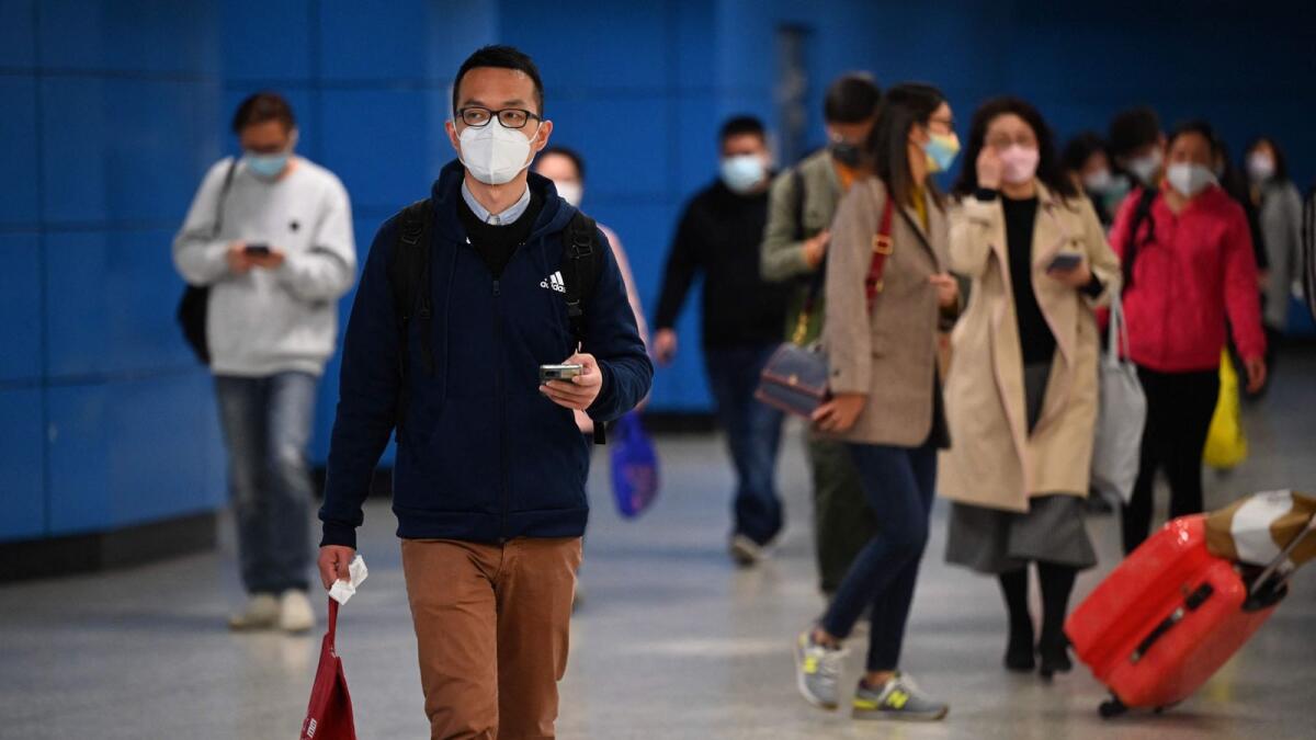People wear masks on the Mass Transit Railway system in Hong Kong. Hong kongers will finally be able to leave home without a face mask. — AFP
