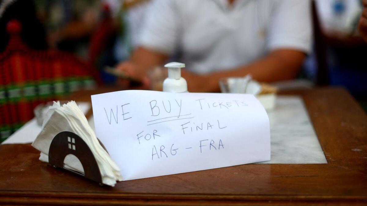 People in Souq Waqif in Qatar put up signs to buy tickets for the Argentina-France World Cup finals. — Reuters