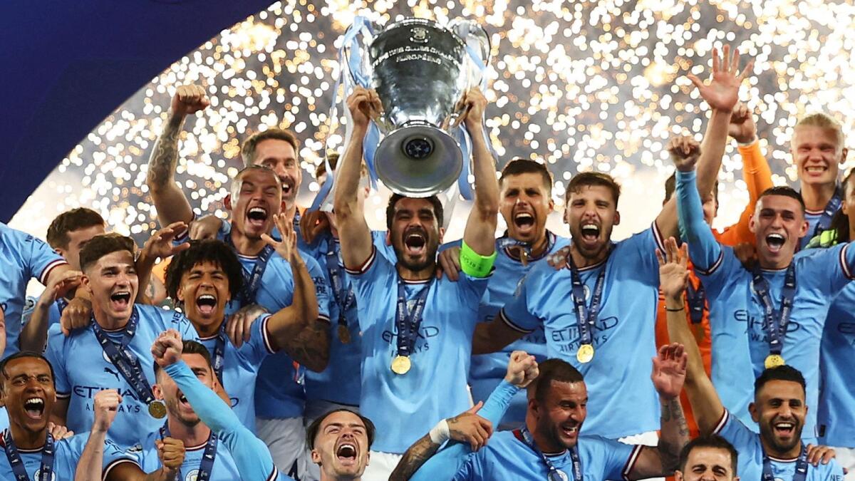 Manchester City's Ilkay Gundogan lifts the trophy as he celebrates with teammates after winning the Champions League. Photos: Reuters