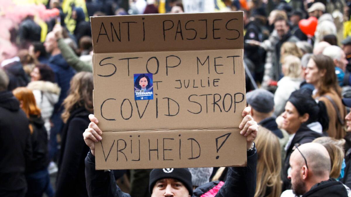 A man shows a poster reading: 'Against Passes. Stop the covid noose. Freedom' during a demonstration against the reinforced measures of the Belgium government in Brussels. – AP