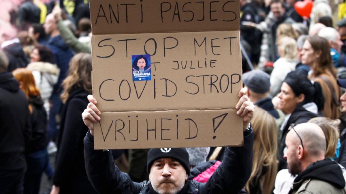 A man shows a poster reading: 'Against Passes. Stop the covid noose. Freedom' during a demonstration against the reinforced measures of the Belgium government in Brussels. – AP