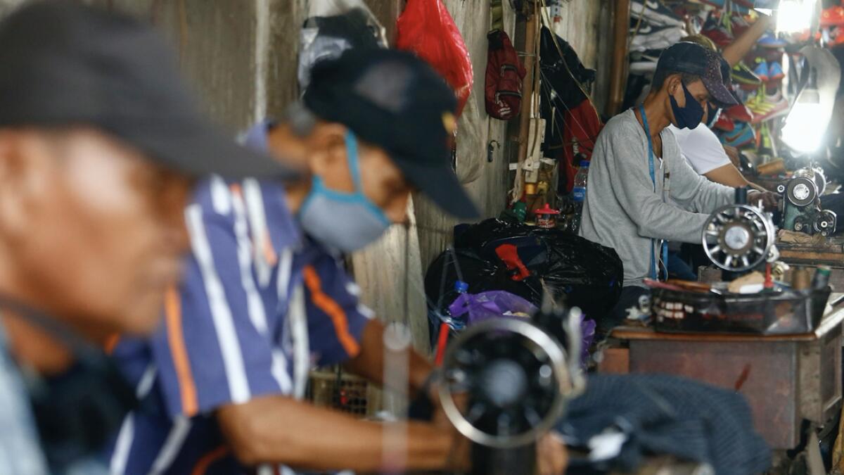 Tailors are seen wearing a protective face mask at an underpass Jatinegara amid the coronavirus disease (Covid-19) in Jakarta, Indonesia. Photo: Reuters
