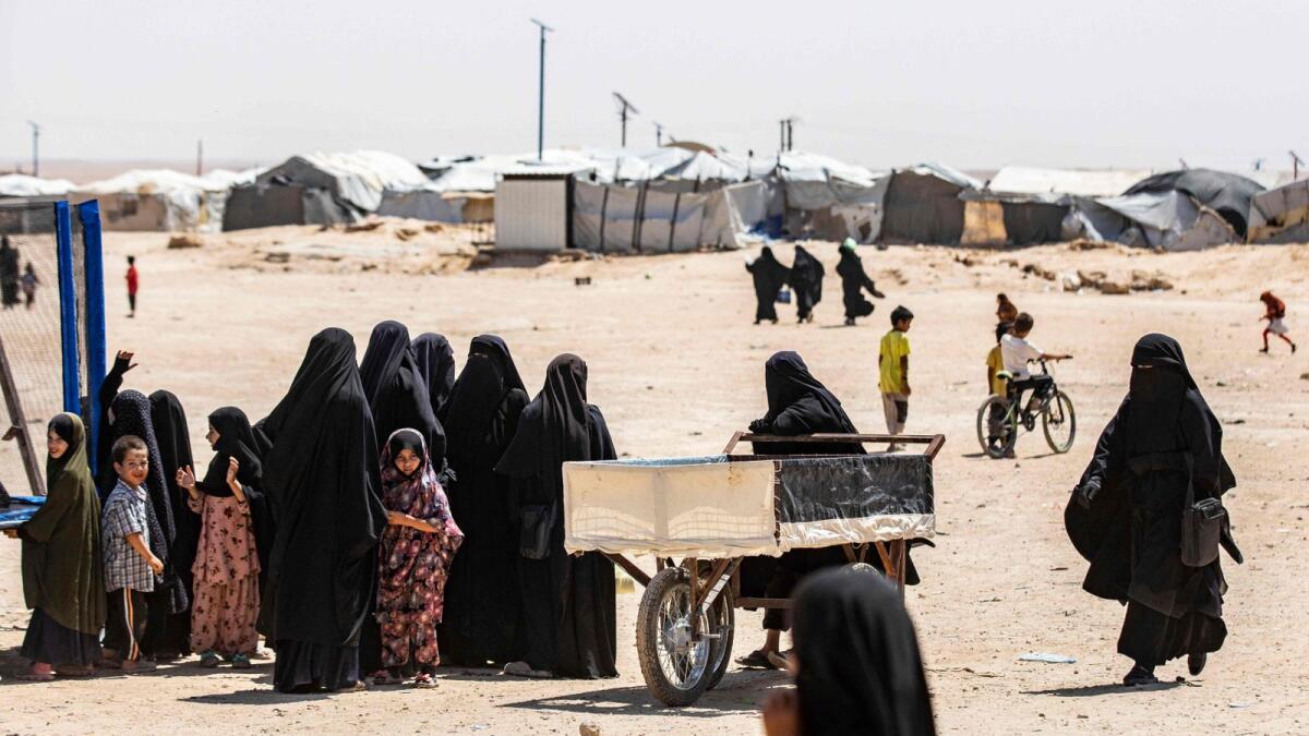 Women and children stand in a queue at the Al Hol camp in Syria's northeastern Al Hasakah Governorate, on October 10, 2023. — AFP