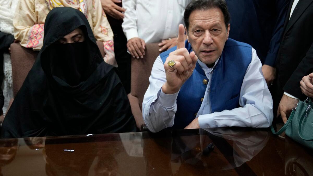 Pakistan's former Prime Minister Imran Khan, right, and Bushra Bibi, his wife, talk to the media before signing documents to submit surety bond over his bails in different cases, at an office of Lahore High Court in Lahore, Pakistan, on July 17, 2023. — AP file