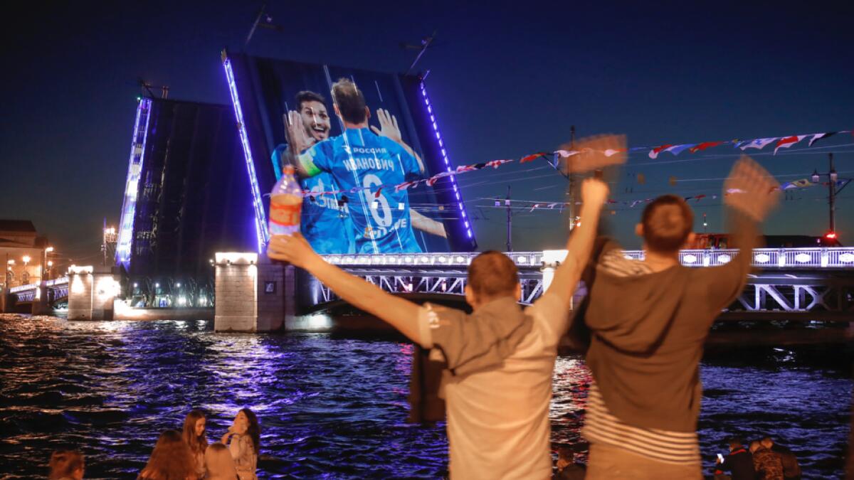 Zenit fans rejoice watching a video of Zenit's matches projected onto the Dvortsovy (Palace) drawbridge rising above the Neva River during celebration of Zenit's victories in St. Petersburg, Russia. Zenit has won Russian national championship and the Cup of Russia. Photo: AP