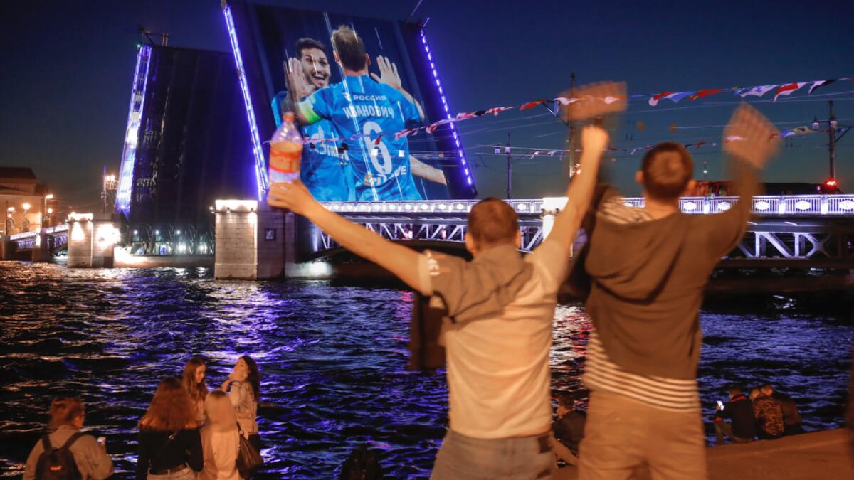 Zenit fans rejoice watching a video of Zenit's matches projected onto the Dvortsovy (Palace) drawbridge rising above the Neva River during celebration of Zenit's victories in St. Petersburg, Russia. Zenit has won Russian national championship and the Cup of Russia. Photo: AP