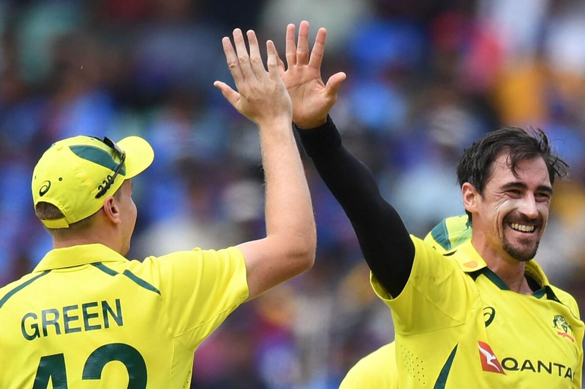Australia's Mitchell Starc (right) celebrates with teammates after taking a wicket against India. — AFP