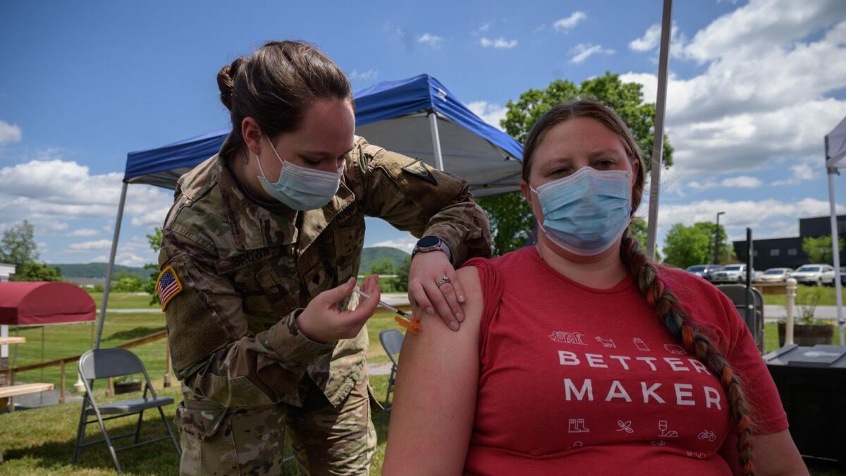 An employee recieves a vaccination against Covid from a soldier at a pop-up vaccination stand in Vermont. Photo: AFP