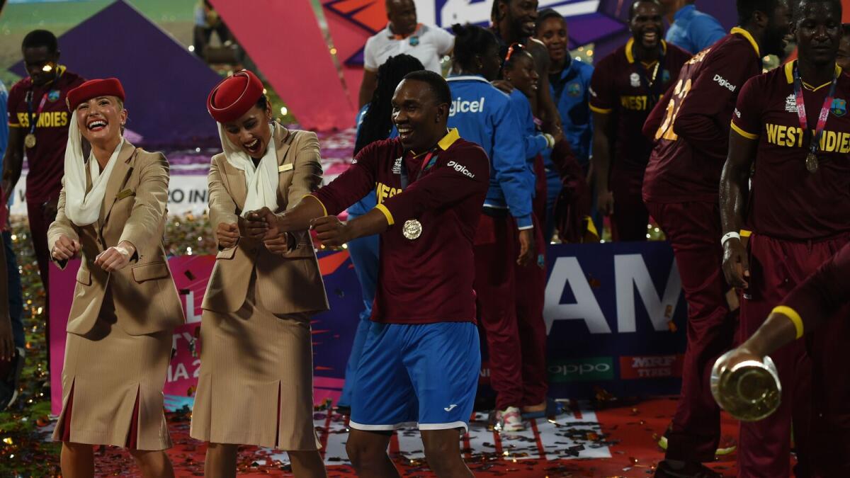 West Indies's Dwayne Bravo(C)dances with air hostesses after victory in the World T20 cricket tournament final match between England and West Indies at The Eden Gardens Cricket Stadium in Kolkata on April 3, 2016.