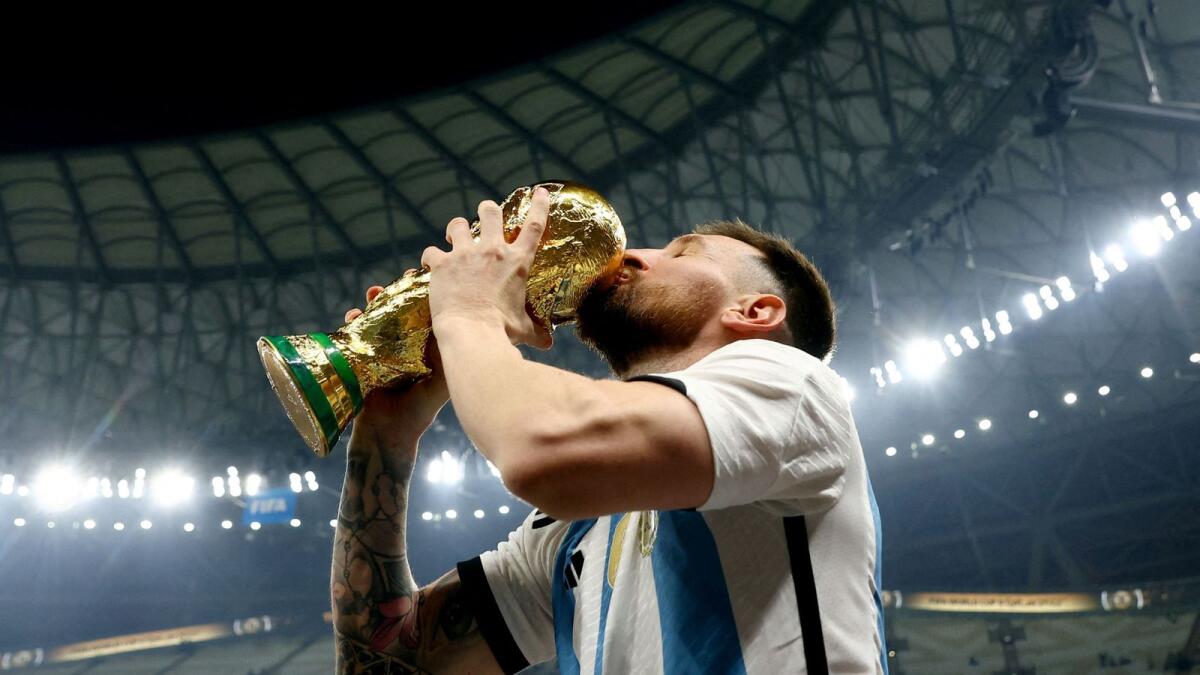 Lionel Messi kisses the trophy as he celebrates winning the World Cup. — Reuters