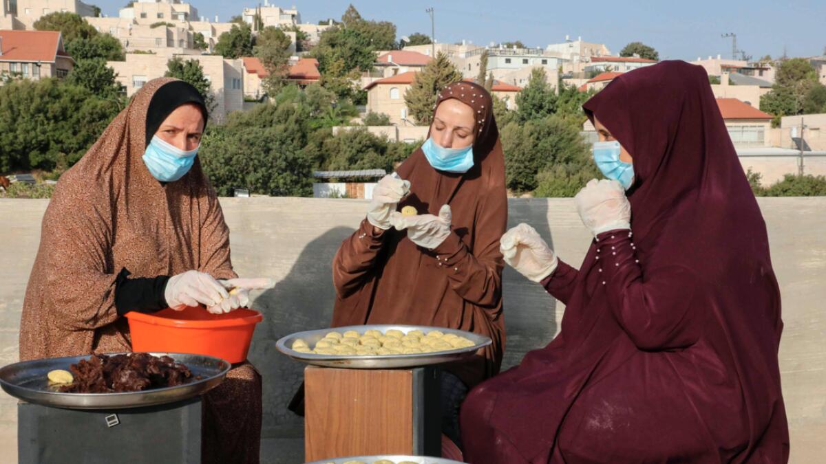 Palestinian women prepare traditional date-filled cookies on the roof of their house in the West Bank town of Hebron in preparation for the Eid Al Adha celebrations. Photo: AFP