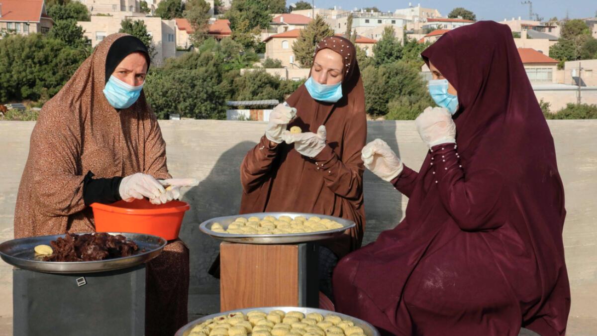 Palestinian women prepare traditional date-filled cookies on the roof of their house in the West Bank town of Hebron in preparation for the Eid Al Adha celebrations. Photo: AFP