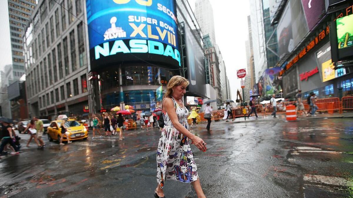 A woman walks past the Nasdaq MarketSite in Times Square, New York. The tech-heavy Nasdaq Composite index rose 8.1 per cent this week to notch its biggest weekly gain since March. - AFP file
