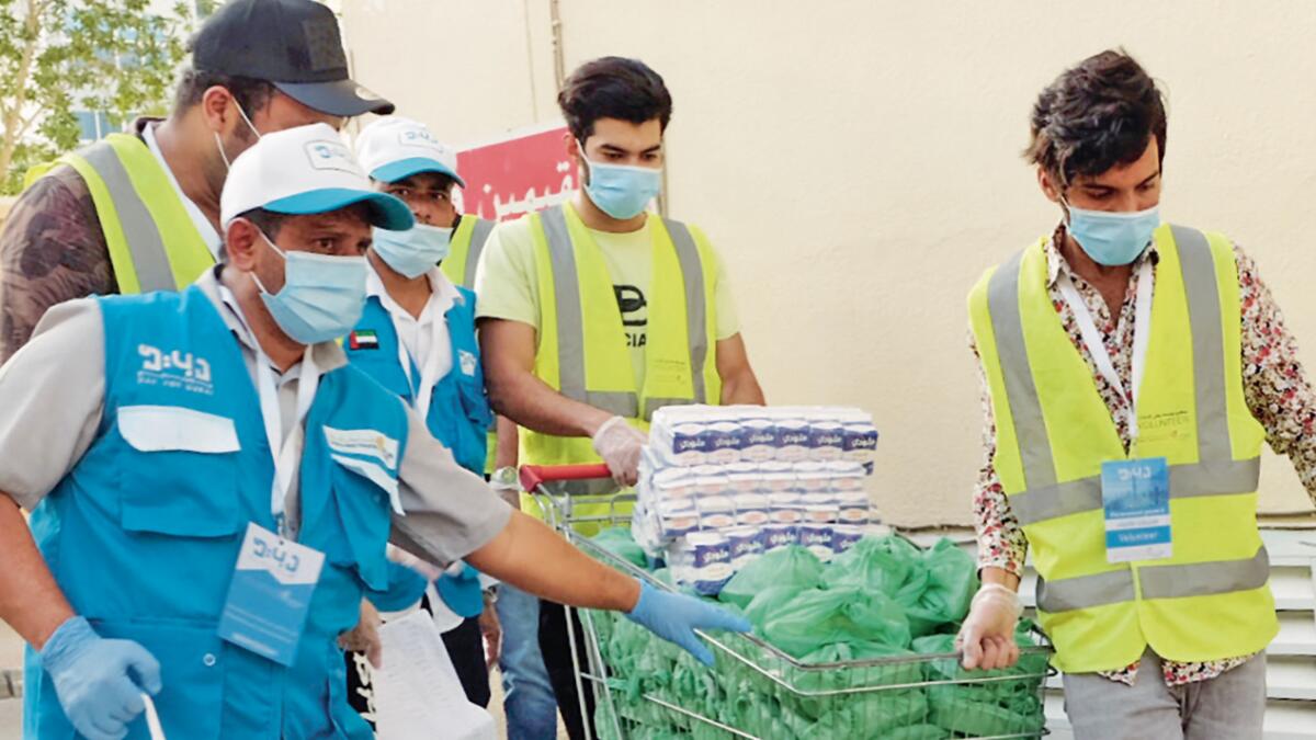 PUTTING THEIR LIVES ON THE LINE: A group of volunteers rushes supplies to distressed families in Dubai’s Karama neighbourhood. Photo: Shihab