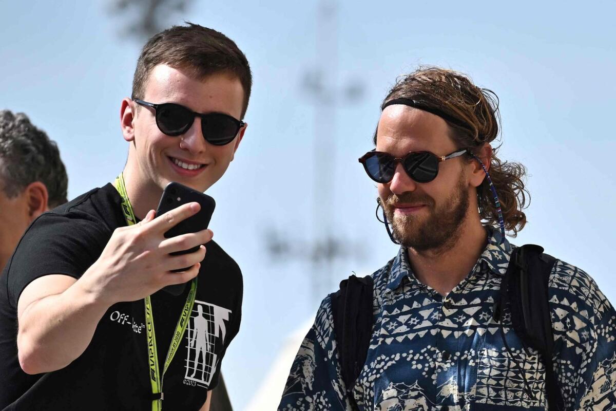 Aston Martin's German Sebastian Vettel (right) poses for a selfie with a fan before the first practice session of the Abu Dhabi Formula One Grand Prix. — AFP