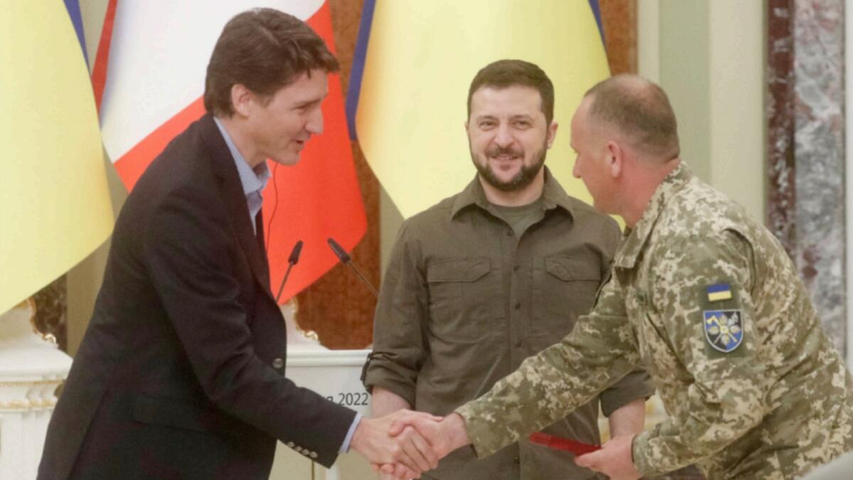 Canadian Prime Minister Justin Trudeau and Ukraine's President Volodymyr Zelensky award a Ukrainian service member during a news conference. — Reuters