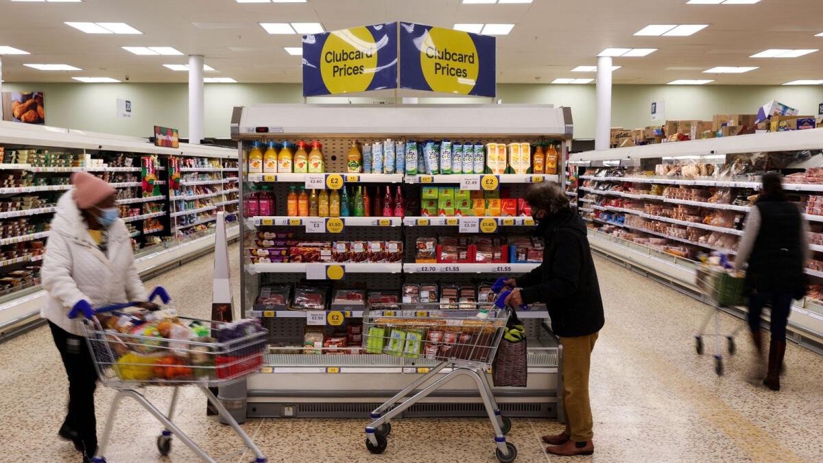 Clubcard branding is seen next to shoppers inside a branch of a Tesco Extra Supermarket in London. Annual consumer price inflation fell to 10.5 per cent in December from November’s 10.7 per cent, the Office for National Statistics said on Wednesday. — Reuters file photo