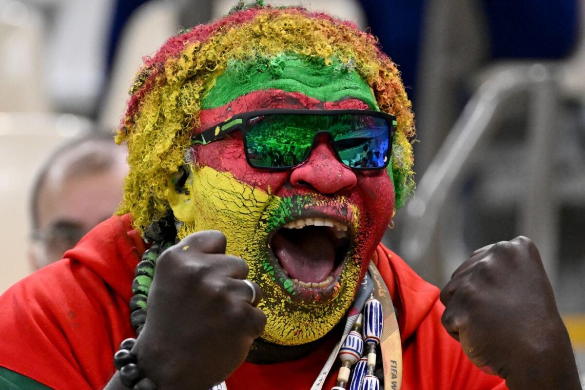 A Cameroon fan with a painted face cheers on his team during the match against Brazil at the Lusail Stadium. (AFP)