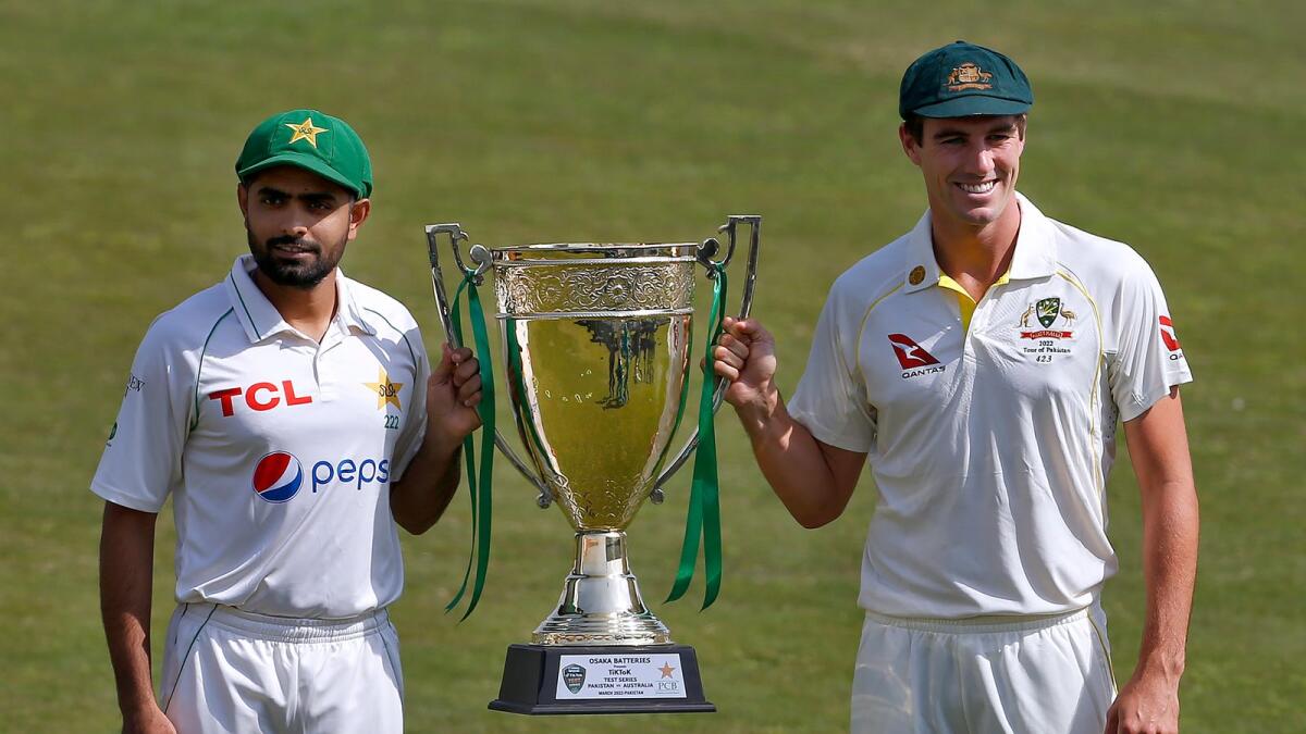 Pakistan skipper Babar Azam (left) and his Australian counterpart Pat Cummins pose for a photo with the Test series trophy in Rawalpindi. (AP)