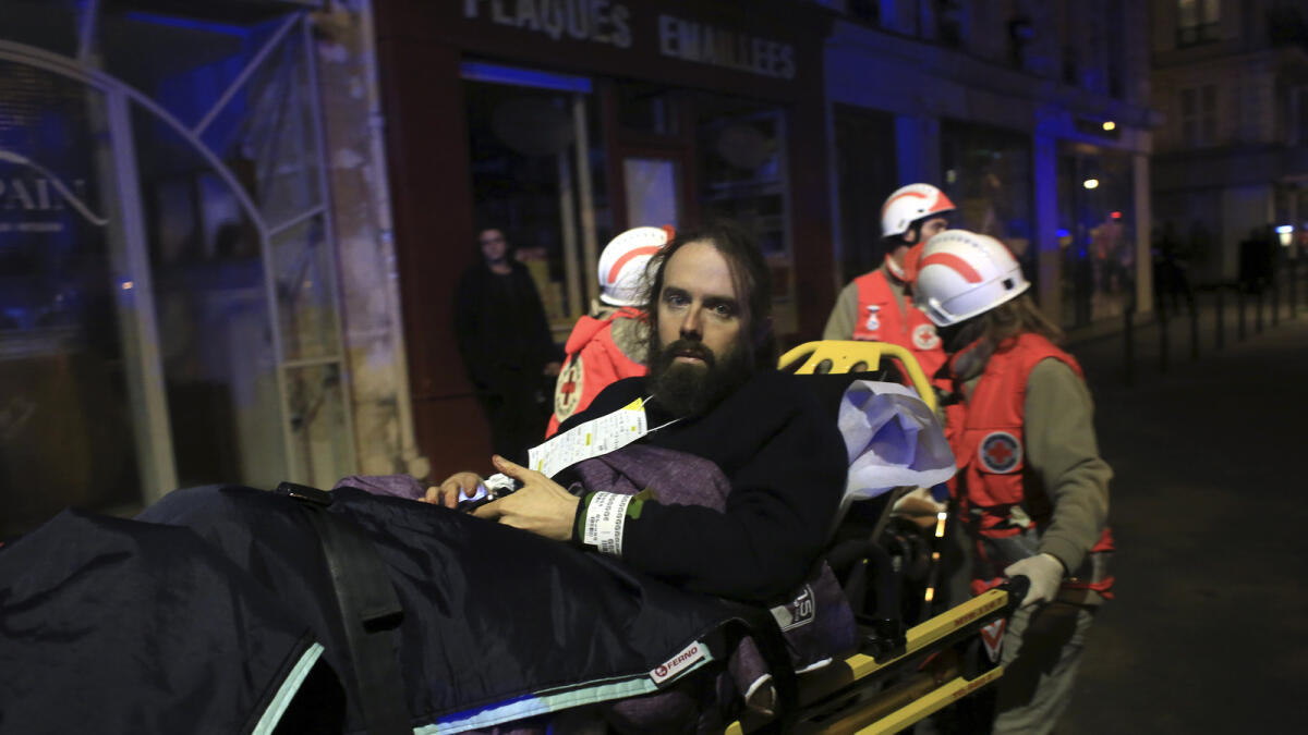 A man is being evacuated from the Bataclan theater after a shooting in Paris, Friday Nov. 13, 2015. AP photo