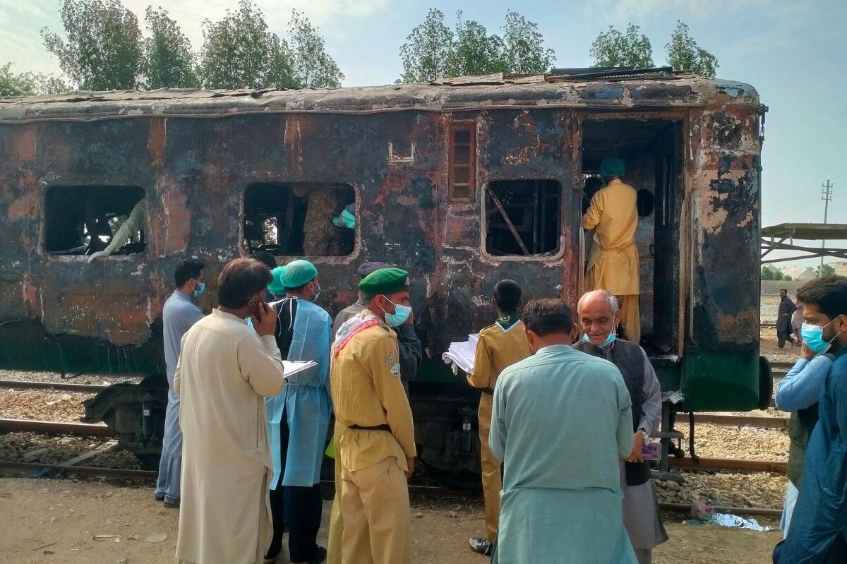 Security officials search for victims inside a burnt out carriage following an overnight fire in the Karachi Express passenger train. Photo: AFP