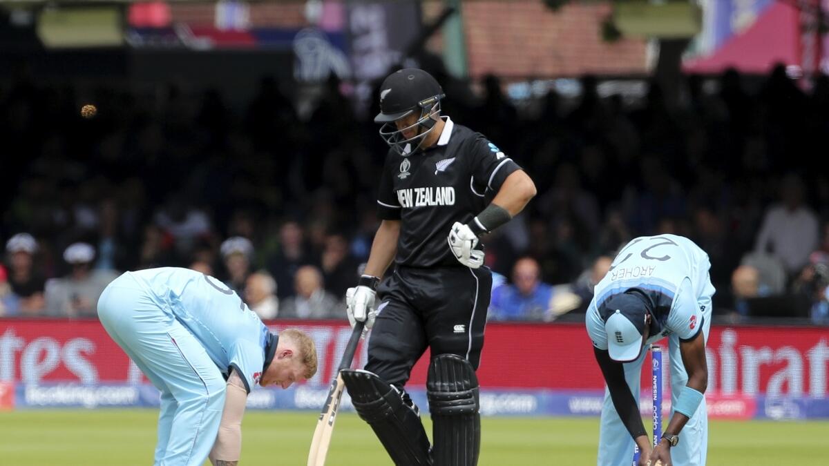 Ross Taylor walks away as Ben Stokes and Jofra Archer fill in the damaged pitch area during the Cricket World Cup final.