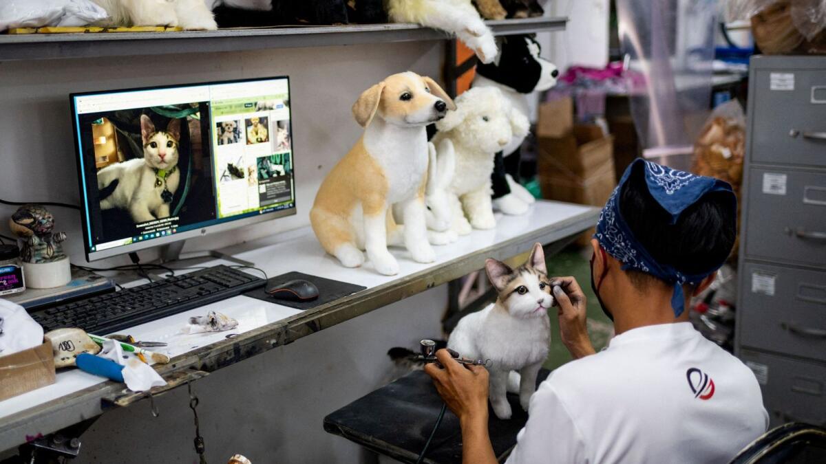 A worker paints the face of a realistic pet plushie, at the Pampanga Teddy Bear Factory, in Angeles City, Pampanga province, Philippines, on March 10, 2023. -- Reuters