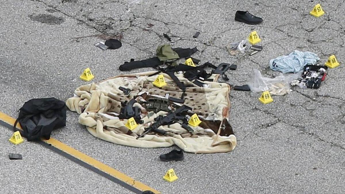 Weapons and other evidence are shown on a tarp near a SUV involved in the attack in San Bernardino, California.