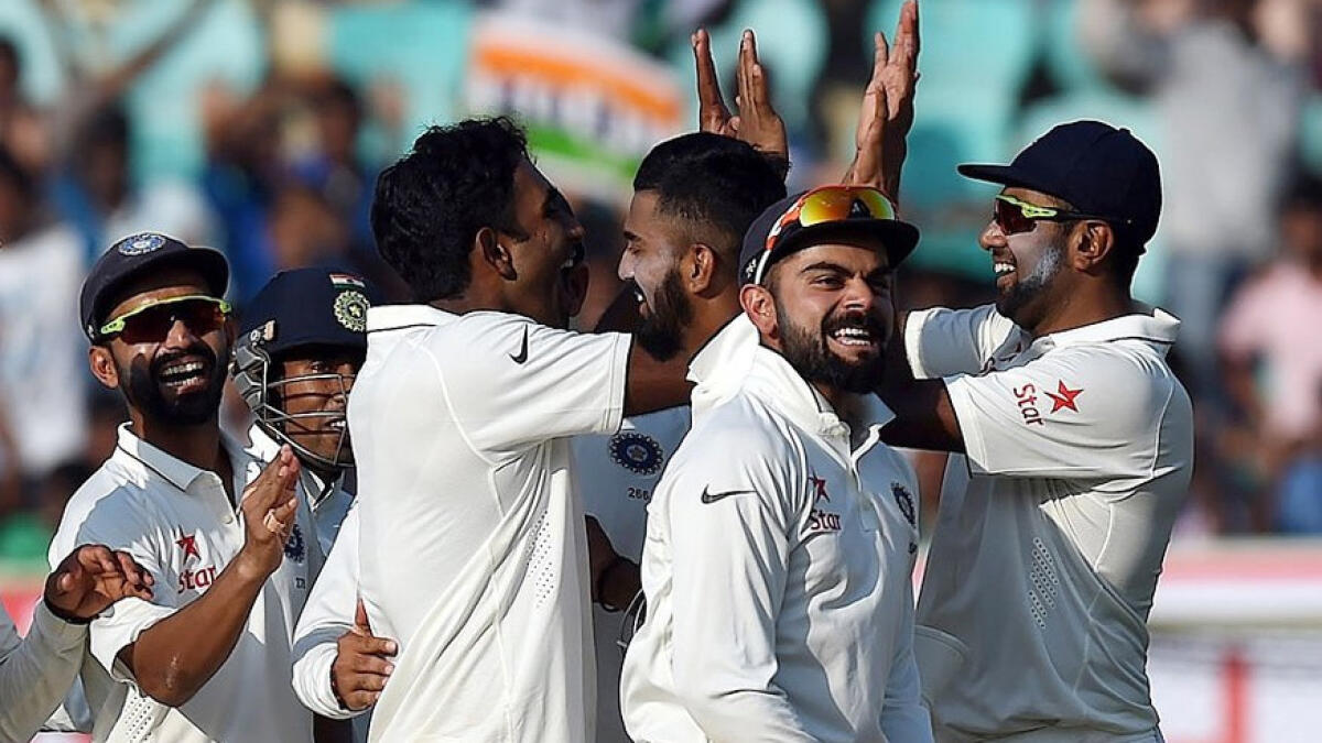 Indias Jayant Yadav, third left without cap, celebrates with teammates the dismissal of Englands Moeen Ali, second right, on the second day of their second cricket test match in Visakhapatnam, 