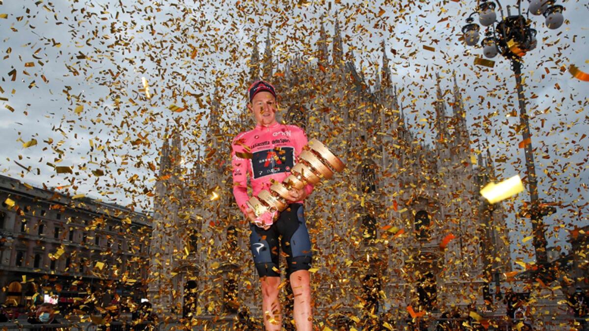 Overall race winner Team Ineos rider Great Britain's Tao Geoghegan Hart wearing the leader's pink jersey holds the Never ending trophy. — AFP