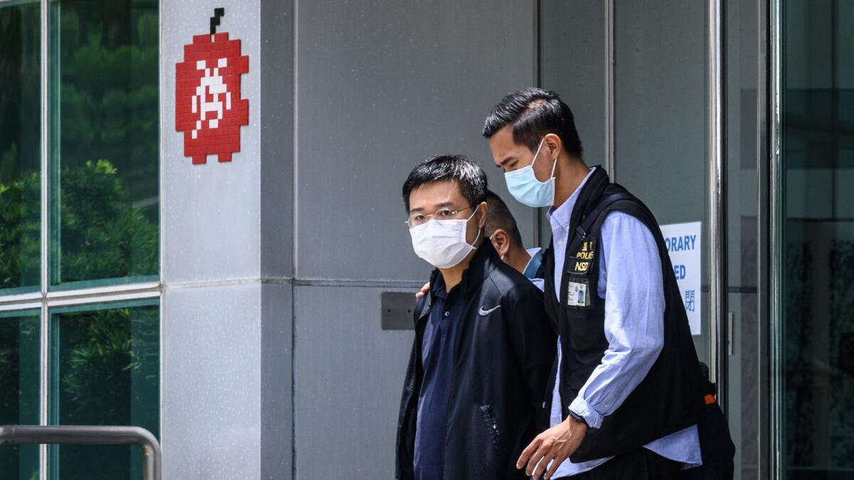 Apple Daily editor-in-chief Ryan Law (centre) is escorted by police to a waiting vehicle from the offices of the local Apple Daily newspaper in Hong Kong. Photo: AFP