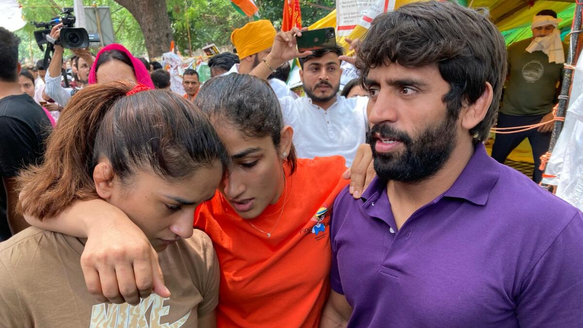 Indian wrestlers Bajrang Punia, Sangita Phogat and Vinesh Phogat talk to each other ahead of their protest march towards the newly inaugurated parliament, in New Delhi. — AP file