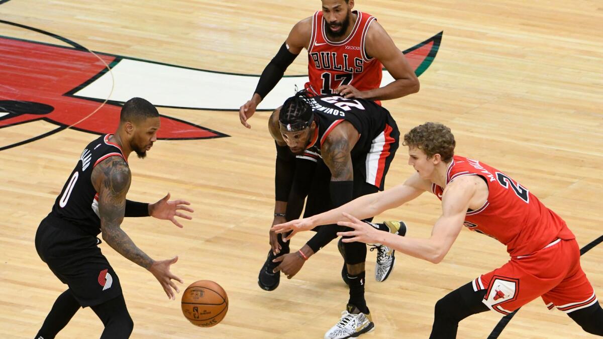 Portland Trail Blazers guard Damian Lillard (0) and Chicago Bulls forward Lauri Markkanen (24) go for a loose ball. — Reuters