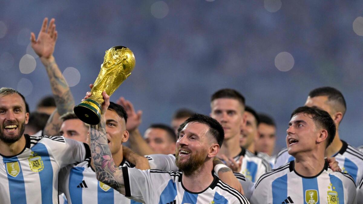 Argentina's Lionel Messi (centre) raises a replica of the World Cup trophy as his teammates look on during a ceremony in Santiago del Estero, in northern Argentina, on March 28. — AFP