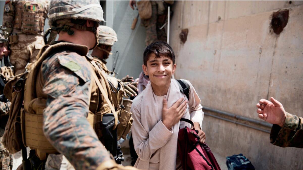 A boy is processed through an Evacuee Control Checkpoint during an evacuation at Hamid Karzai International Airport in Kabul. — AP