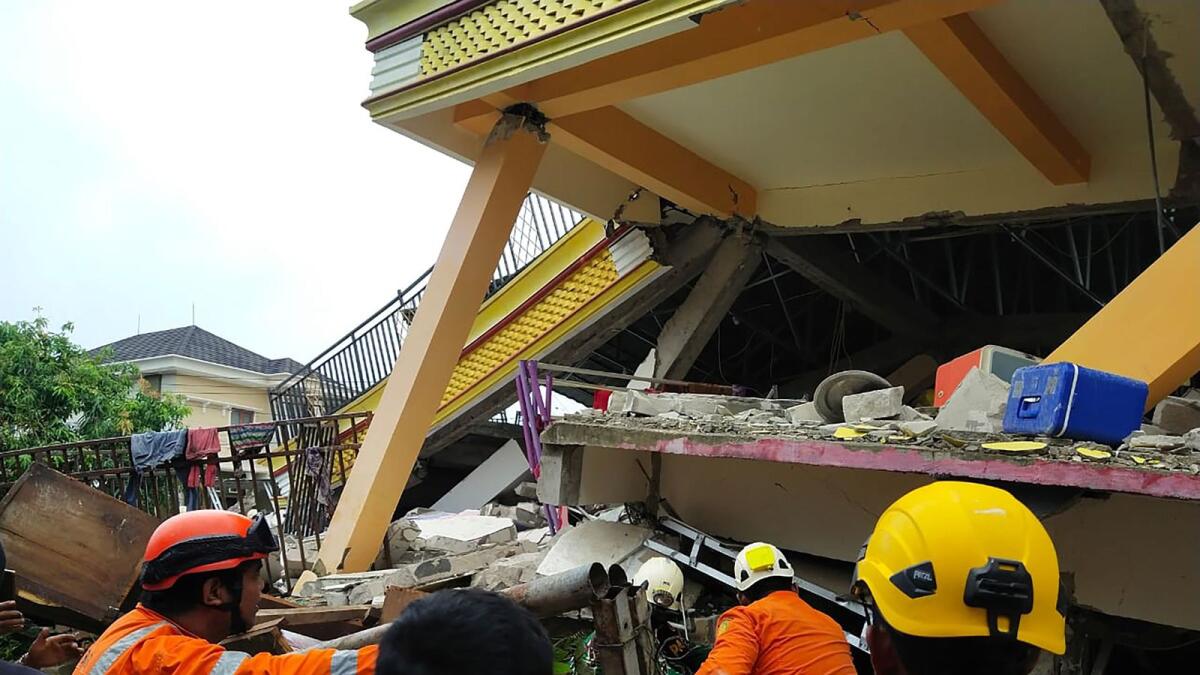 Rescuers looking for survivors trapped in a collapsed building in Mamuju, after a 6.2-magnitude earthquake rocked Sulawesi island. AFP