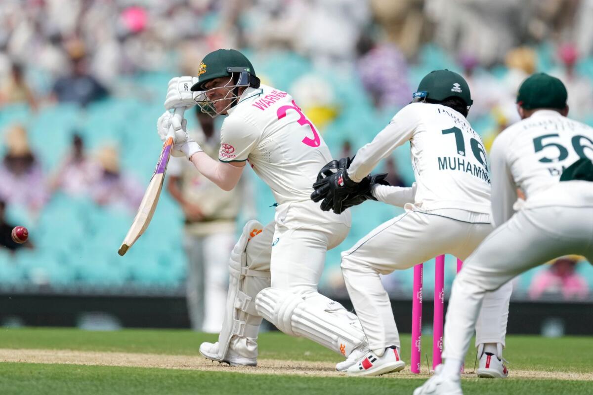 Australia's David Warner plays a shot as Pakistan's Mohammad Rizwan and Babar Azam look on during the second day of their cricket Test match in Sydney. - AP
