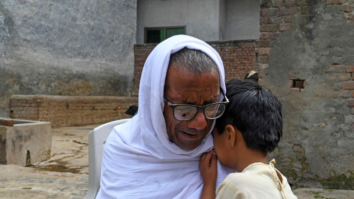 Mohammed Inayat (L), grandfather of Ali Hasnain who died in Libya boat capsizing along with other migrants last month, weeps while speaking with AFP at his house in Gujrat district of Punjab province. — AFP