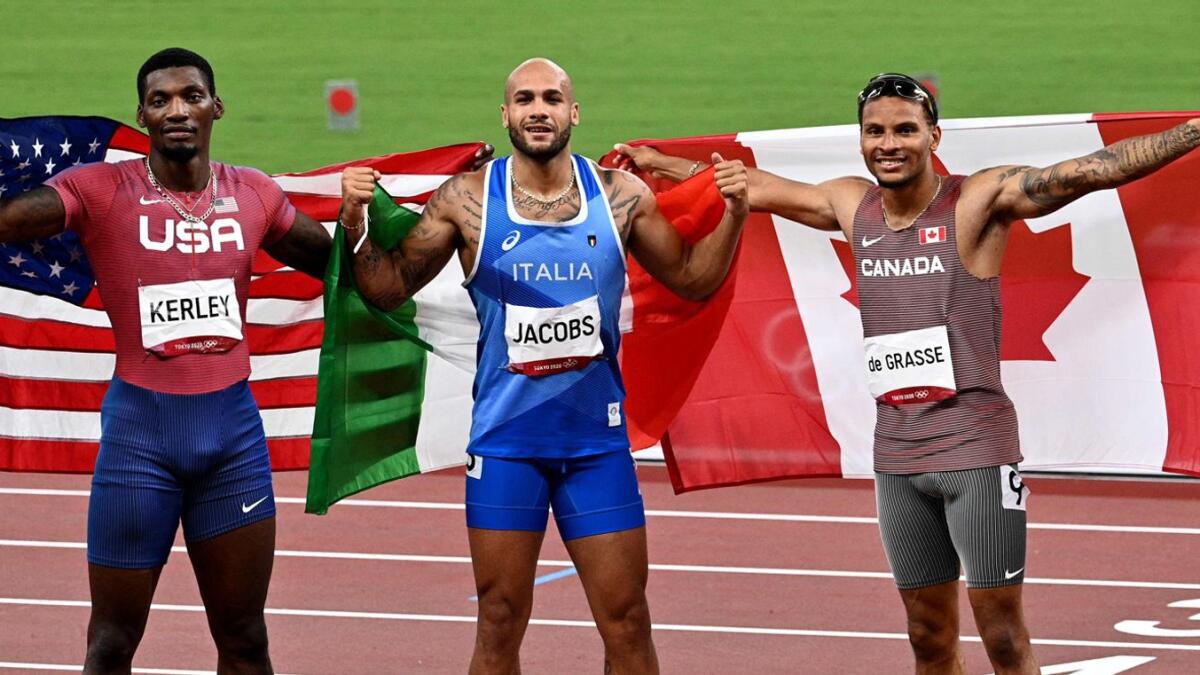 (Left to right) Silver medallist USA's Fred Kerley, gold medallist Italy's Lamont Marcell Jacobs and bronze medallist Canada's Andre De Grasse celebrate after the men's 100m final. — AFP