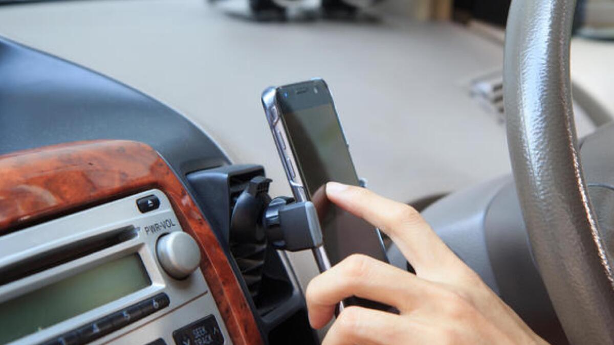 Fine, black point for using mobile phone holder while driving in Oman 